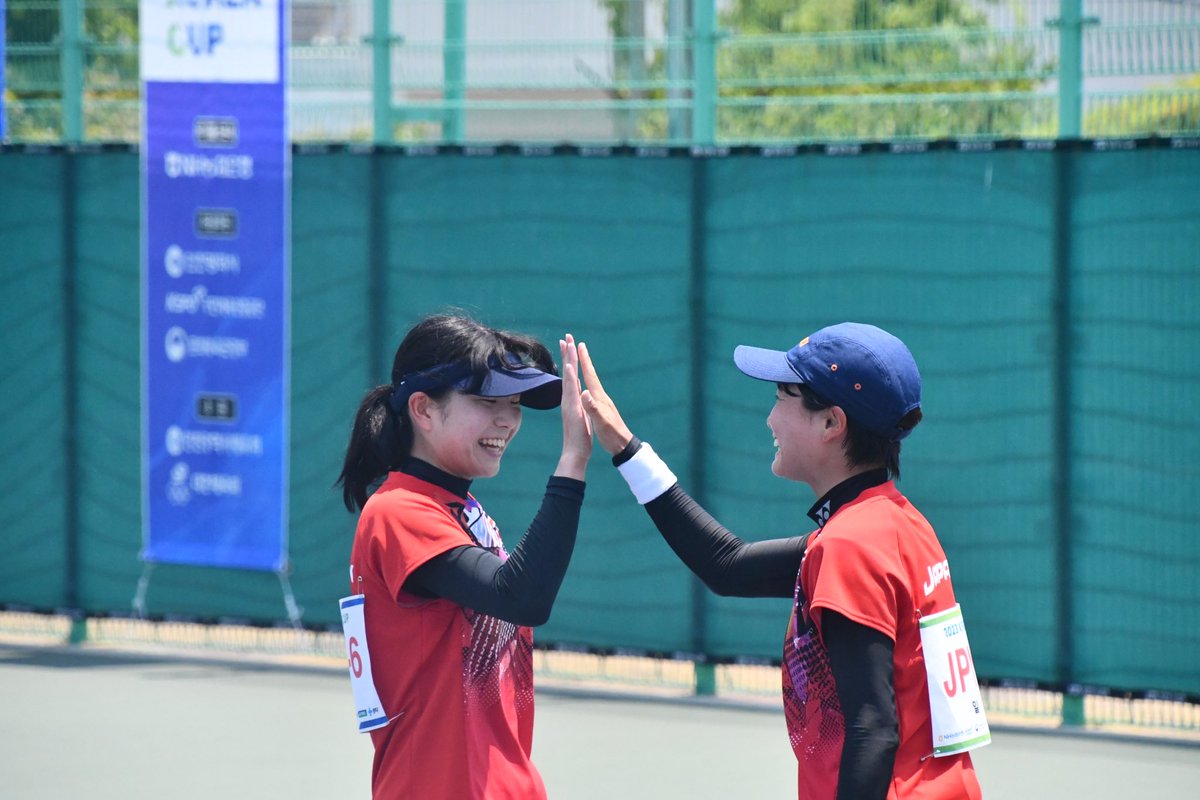 ソフトテニス女性二人がハイタッチしている写真